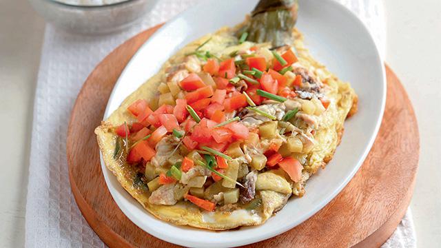 tortang talong or eggplant omelet with smoked bangus topped with chopped tomatoes